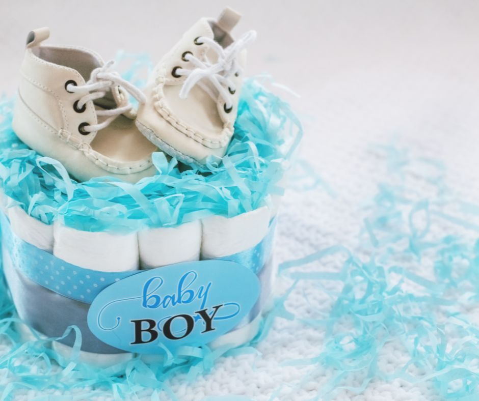 Diaper cake topped with baby shoes in blue décor, representing a Baby Shower Bliss setup from Smart Bride.